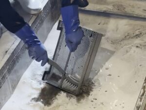 バスケットの油汚れをブラシでこすり洗い