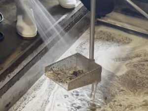 洗浄後のバスケットを水で洗い流す様子